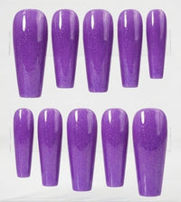 Ten purple glitter press-on nails arranged in two rows on a clear display stand against a white background.
