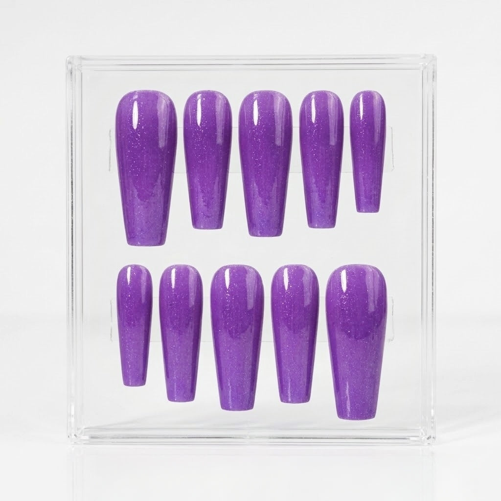 A set of ten purple glitter press-on nails displayed in a clear acrylic box against a white background.