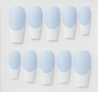 Ten coffin-shaped press-on nails arranged in two rows on a light gray background. Each nail features a light blue base and white french tips.