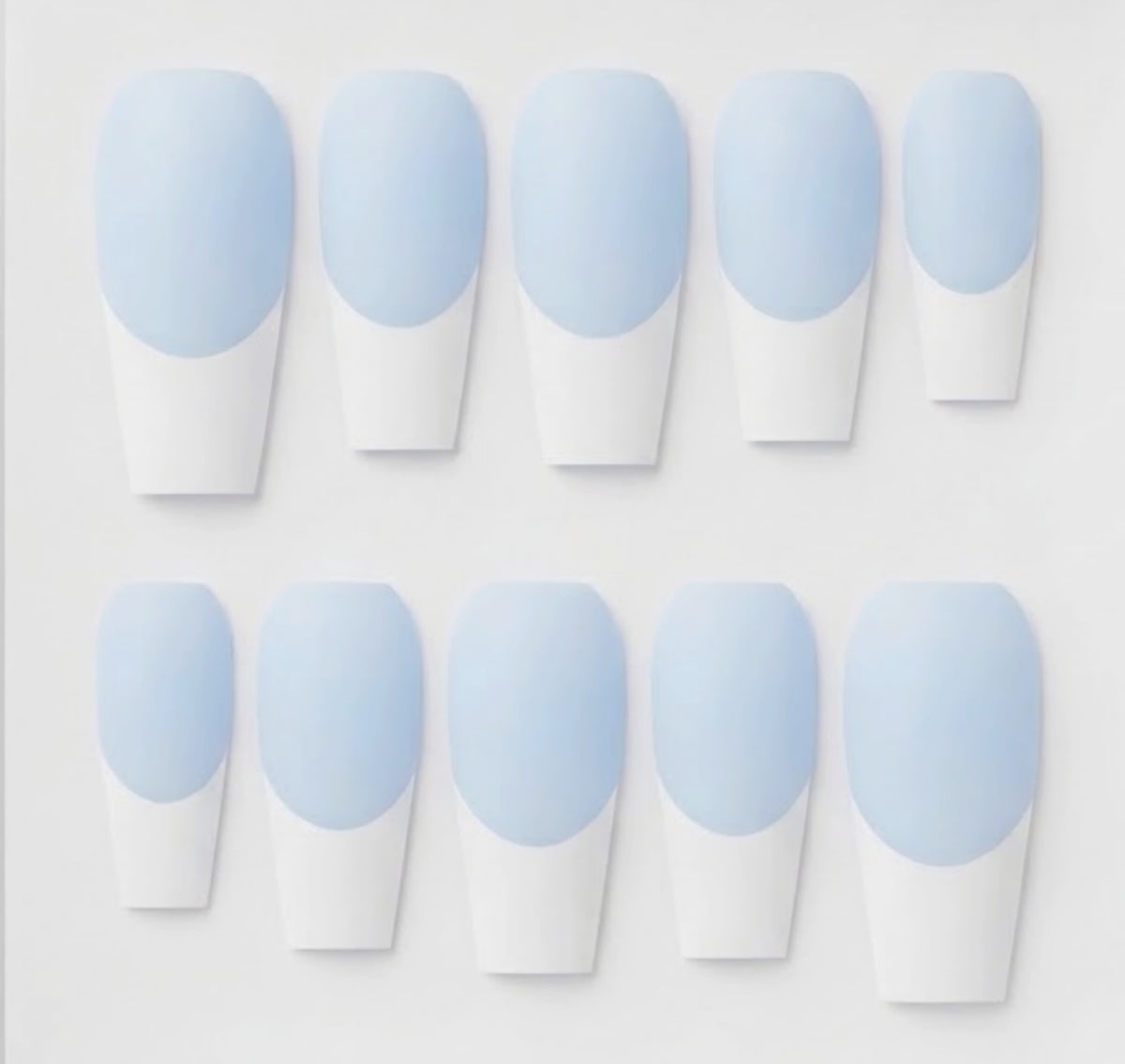 Ten coffin-shaped press-on nails arranged in two rows on a light gray background. Each nail features a light blue base and white french tips.