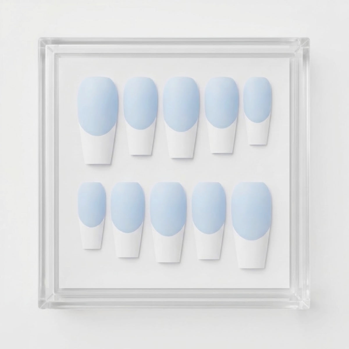 A set of ten coffin-shaped press-on nails with a light blue and white French tip design, displayed inside a clear acrylic square frame against a white background.
