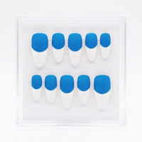 A set of ten press-on nails arranged in two rows inside a clear plastic display case. The nails have a bold two-tone design with a vibrant blue base and white  french tips.