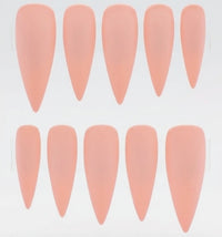 Ten stiletto-shaped press-on nails in a soft peachy pink color, arranged in two rows of five on a plain white background.