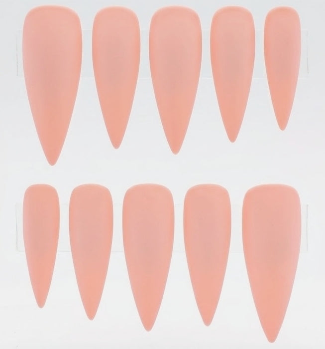 Ten stiletto-shaped press-on nails in a soft peachy pink color, arranged in two rows of five on a plain white background.