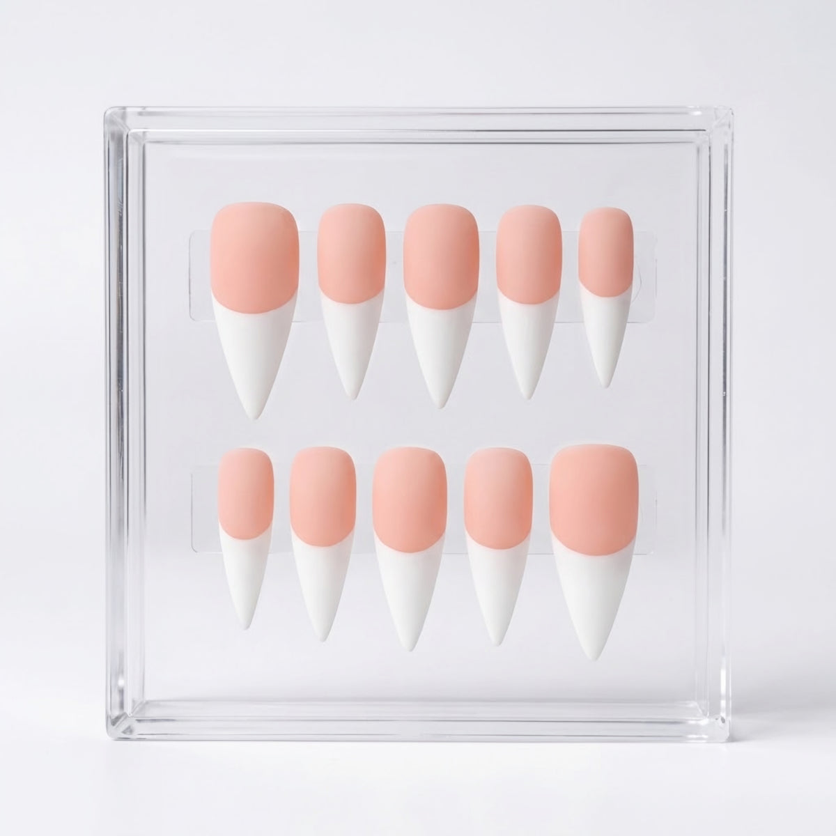 Ten false press-on nails arranged in two rows inside a clear acrylic display box. The nails have a soft peach-pink base and white french tips.