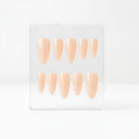 Ten nude Glossy beige almond press-on nails, displayed inside a clear plastic case against a clean white background.