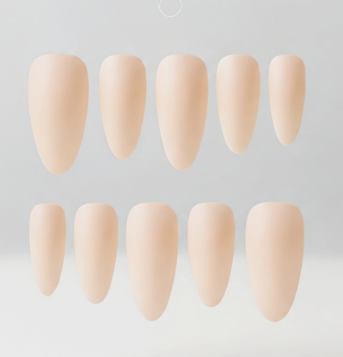 Ten nude-colored nail tips in various lengths arranged in two rows on a light gray background.