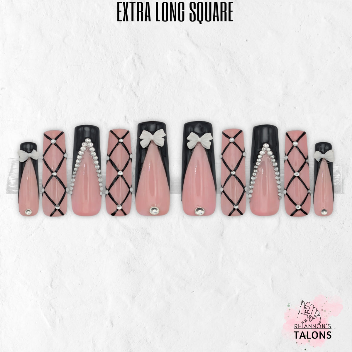 Black Tie Barbie pink and black press-on nails with crystal lattice nail art, 3D bow charms and glossy extra long square false nails.