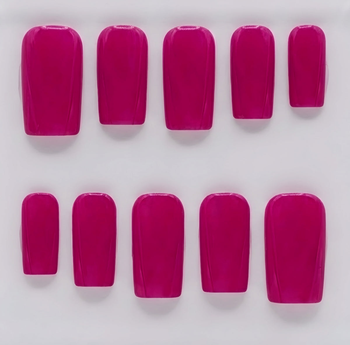 Ten artificial press-on nails in a glossy berry pink color, arranged in two rows of five on a plain white background.