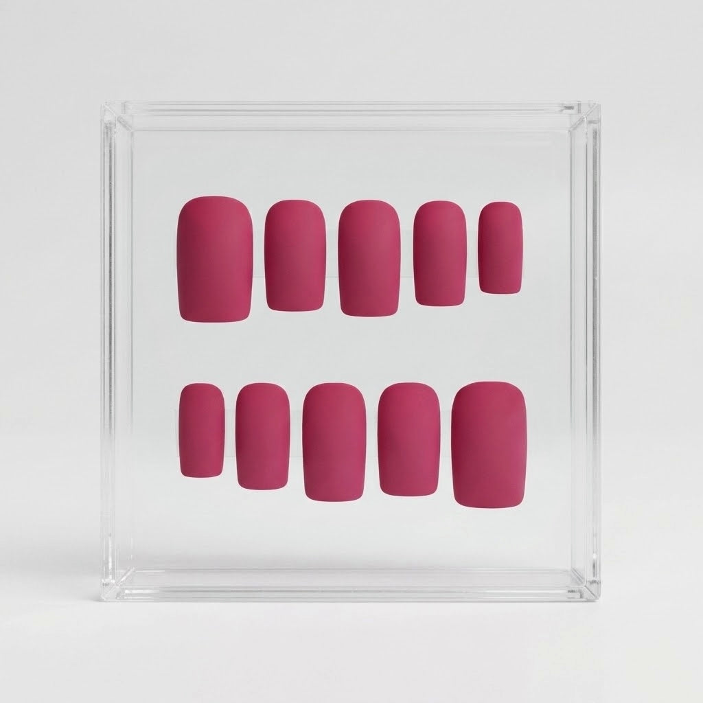 A set of ten false press-on nails in a dusty berry pink color, arranged inside a clear acrylic display box on a light gray background.