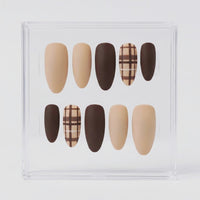 A set of 10 press-on nails displayed in a clear acrylic case against a light gray background. The nails feature a mix of solid nude beige, dark brown, and brown-and-beige plaid patterns.