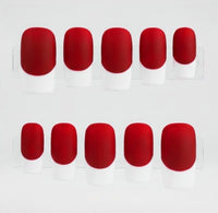 Ten false press-on nails arranged in two rows of five on a clear display stand, featuring a bright matte red base and a white french tip, set against a plain white background.