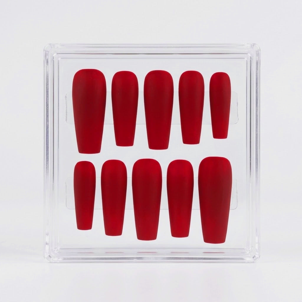 Red matte coffin shaped press on nails in a clear case on a white background.