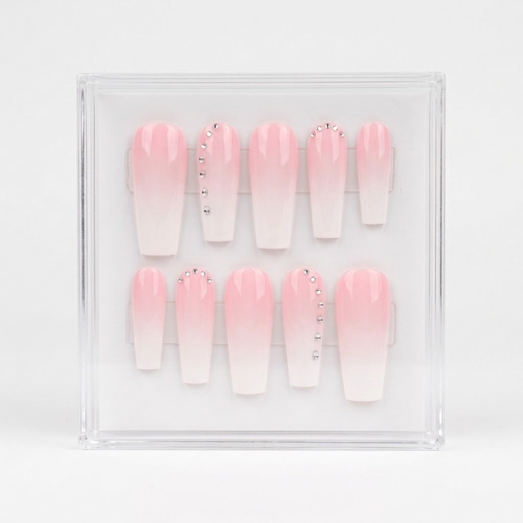 A set of 10 coffin-shaped press-on nails with a pink-to-white ombre gradient, displayed inside a clear acrylic case on a white background.