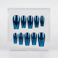A set of ten coffin-shaped press-on nails with a metallic blue chrome finish, displayed inside a clear acrylic case on a white background.