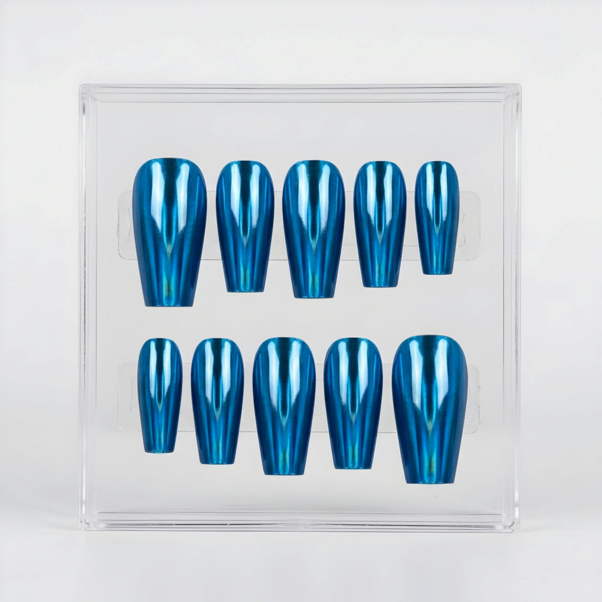 A set of ten metallic blue chrome press-on nails arranged in two rows inside a clear plastic display box, photographed against a clean white background.