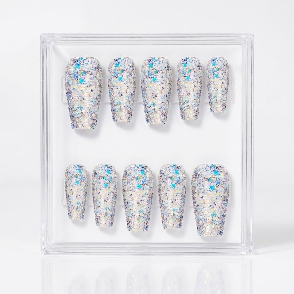 A set of ten press-on nails in a clear square display case, featuring chunky silver iridescent glitter.