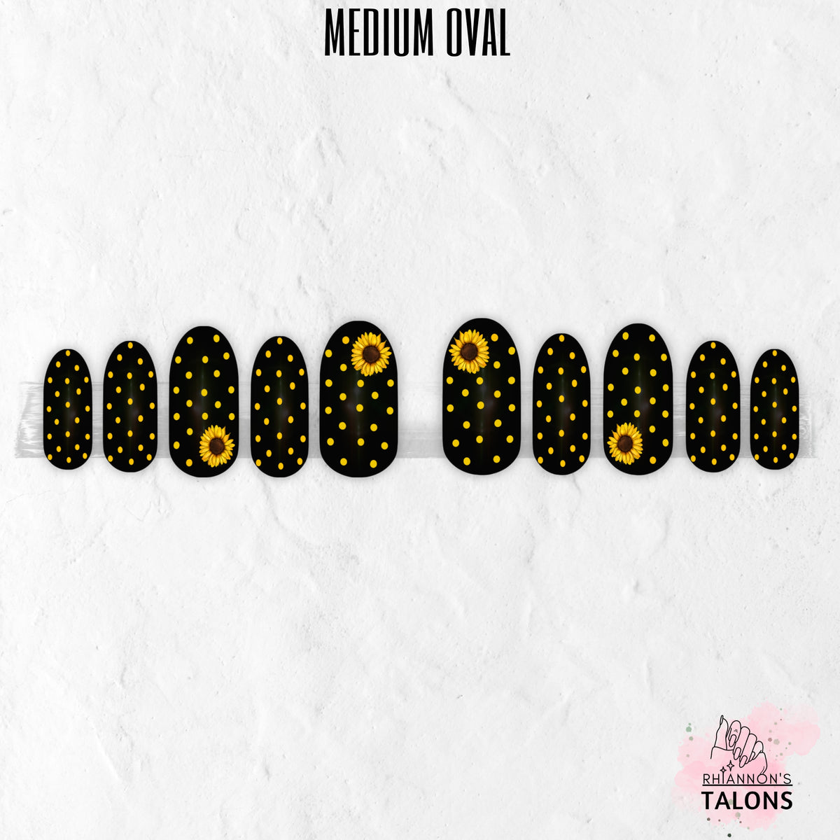 Black and yellow press-on nails with polka dots and sunflower nail art in medium oval shape.