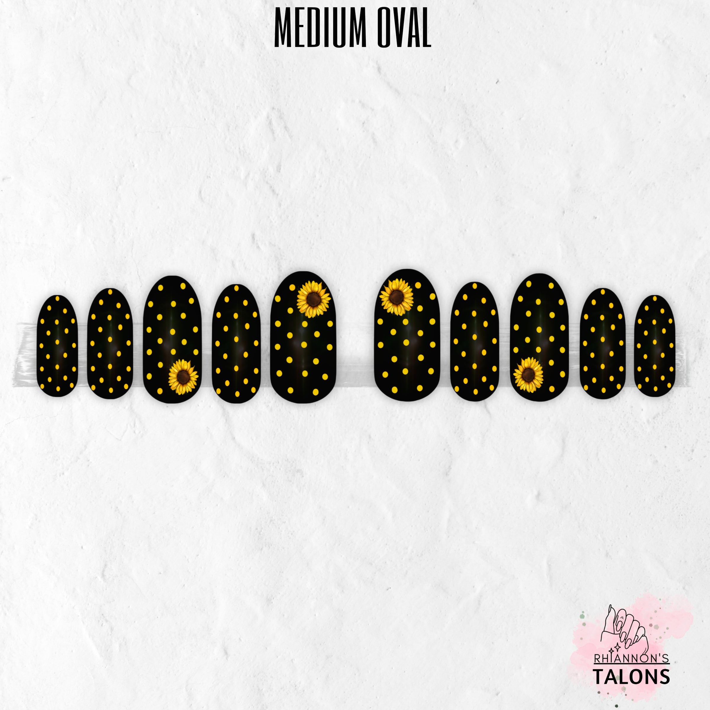 Black and yellow press-on nails with polka dots and sunflower nail art in medium oval shape.
