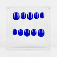A set of ten false press-on nails with a glossy neon blue base and a white french tips, displayed inside a clear acrylic square box on a white background.