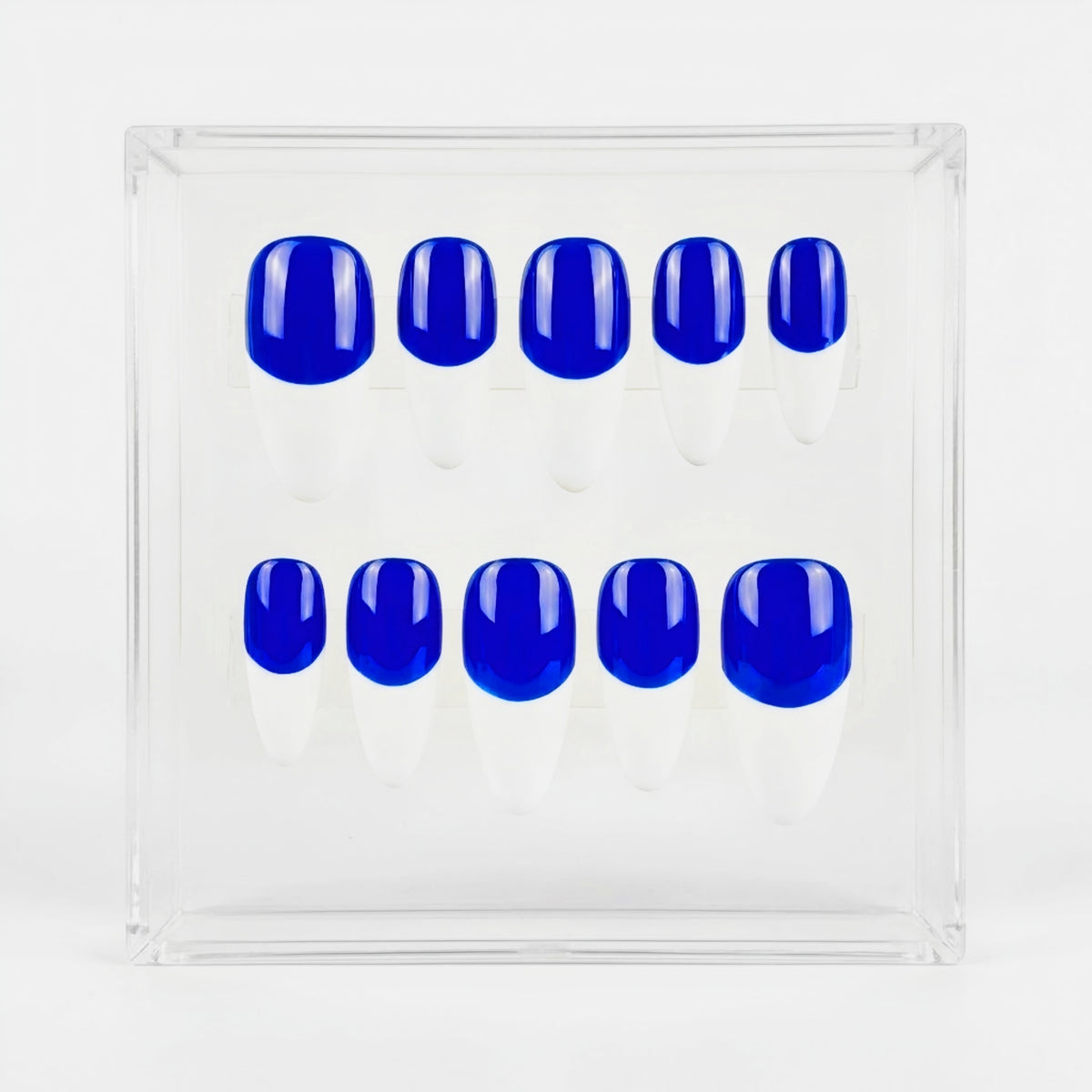 A set of ten false press-on nails with a glossy neon blue base and a white french tips, displayed inside a clear acrylic square box on a white background.