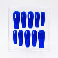 Ten glossy neon blue press-on nails arranged in two rows inside a clear plastic display case on a white background.