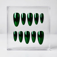 A set of ten glossy metallic chrome green press-on nails displayed in a clear acrylic holder against a light gray background.