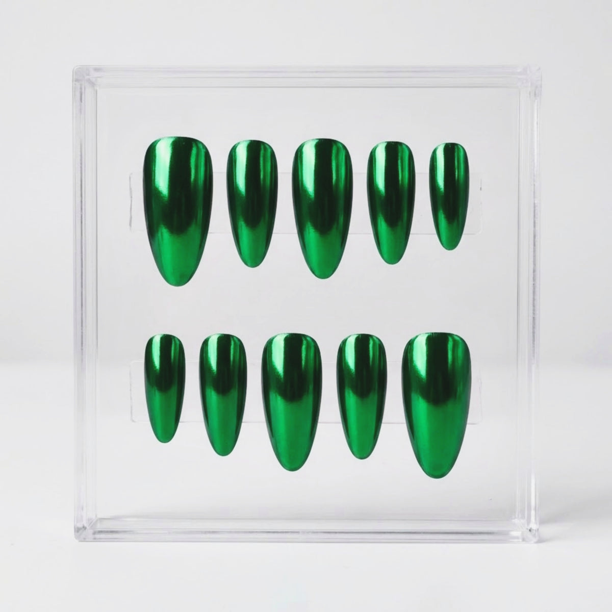 Ten metallic emerald chrome green press-on nails arranged in two rows inside a clear acrylic display box on a light gray background.