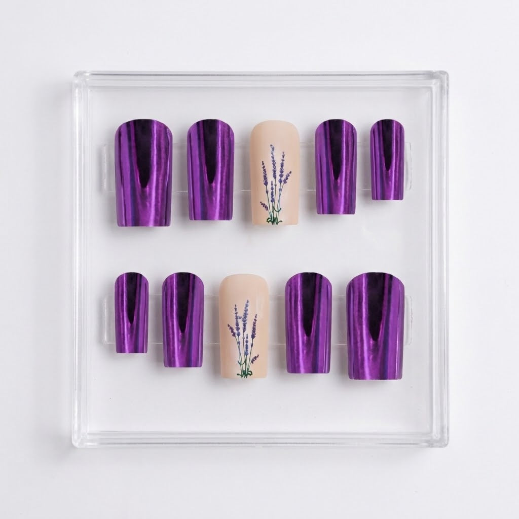 A set of press-on nails displayed in a clear plastic tray on a white background. The set features five metallic purple almond-shaped nails, two beige square-shaped nails with a lavender plant illustration, and four matching metallic purple oval nails.