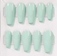 Ten glossy mint green press-on nails arranged in two rows on a clear plastic display card against a white background.