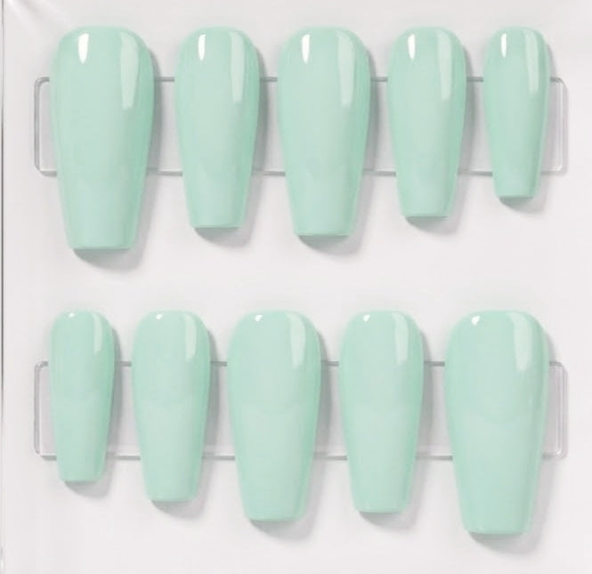 Ten glossy mint green press-on nails arranged in two rows on a clear plastic display card against a white background.