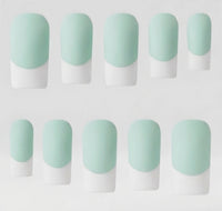 Ten press-on nails arranged in two rows on a plain light background. Each nail has a rounded almond shape with a pale mint green base and white french tips, creating a French manicure-style color-block look.