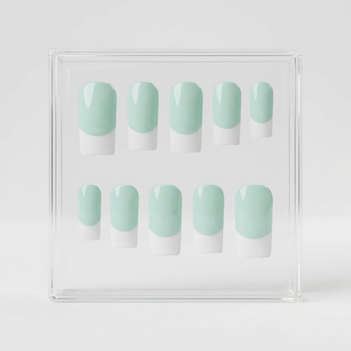 Ten press-on nails with a mint green and white French tip design, displayed inside a clear acrylic case on a light gray background.