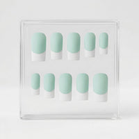 A set of ten press-on nails displayed in a clear acrylic box, featuring a mint green and white French tip design.