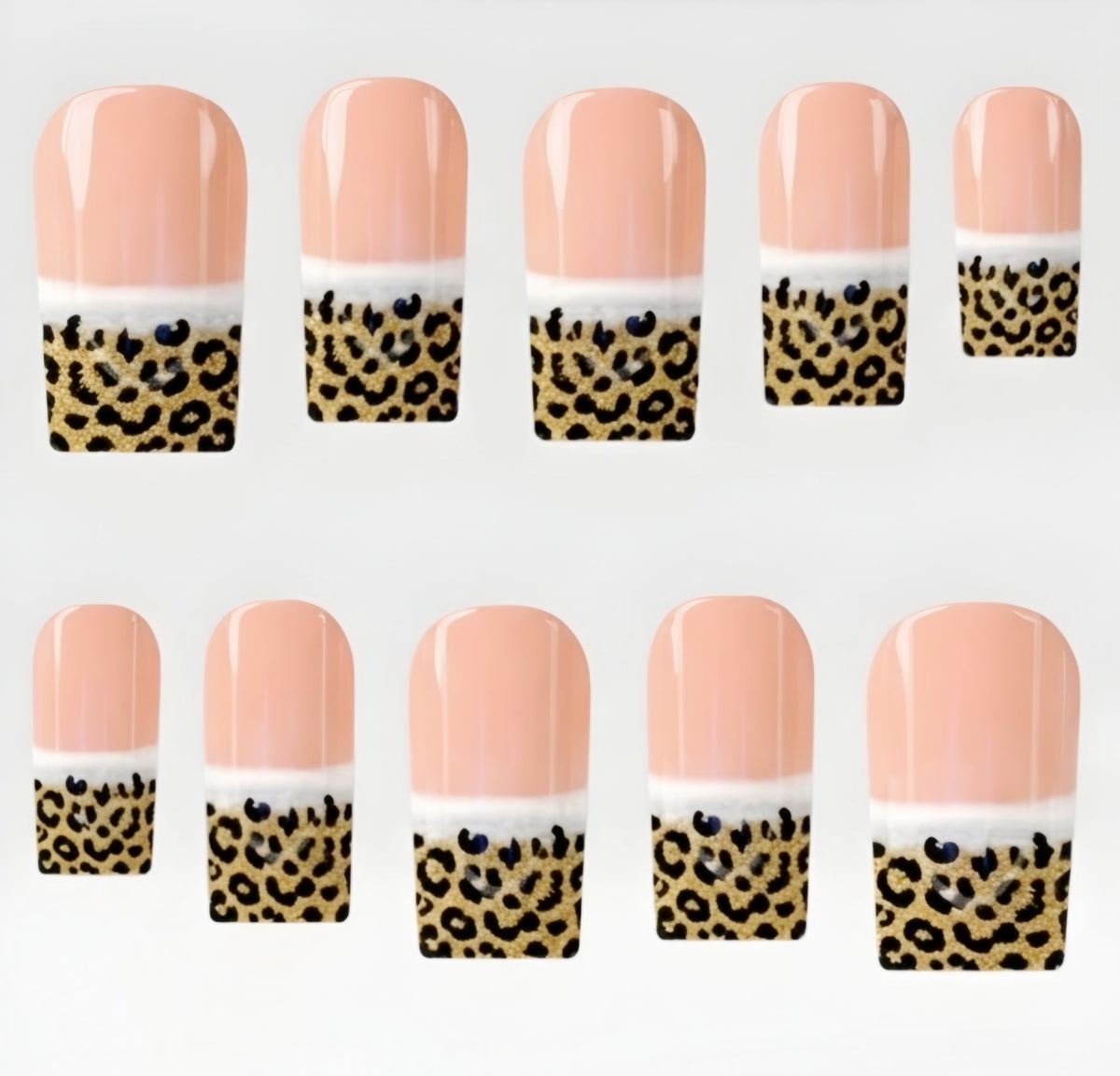 Ten square press on nails arranged in two rows on a plain white background. Each nail has a glossy peach-pink top section, a thin white band, and a leopard-print lower section with black spots on a gold background.