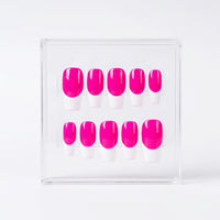 Ten press-on nails with a bright neon pink base and white french tips, displayed in a clear acrylic box on a white background.