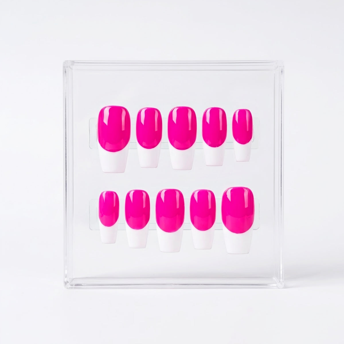 Ten press-on nails with a bright neon pink base and white french tips, displayed in a clear acrylic box on a white background.