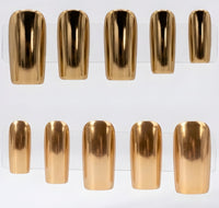 Ten metallic gold chrome press-on nails arranged in two rows on a clear display stand against a white background.