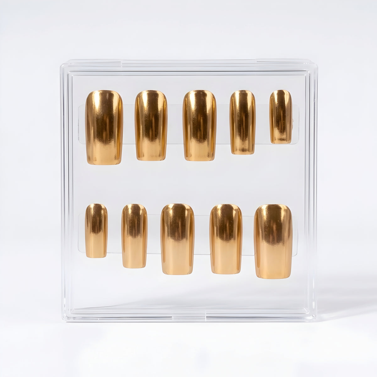 Ten metallic gold  chrome press-on nails arranged inside a clear plastic display box on a white background.