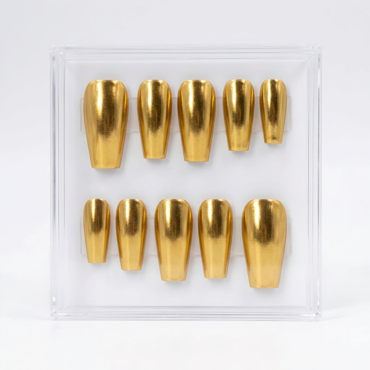 A set of metallic chrome gold press-on nails displayed inside a clear plastic case on a white background.