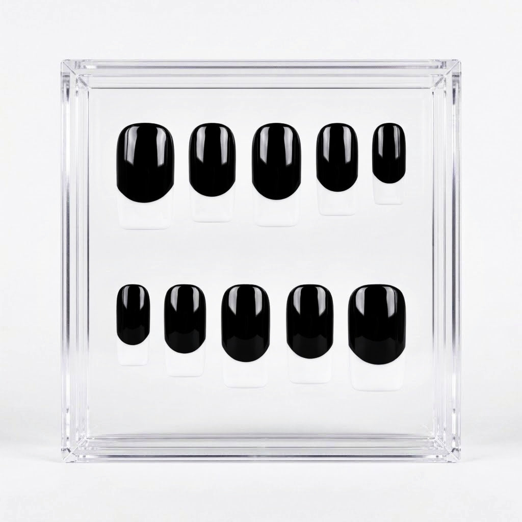 Ten black press-on nails with white french tips, arranged in two rows inside a clear acrylic display box on a white background.