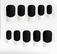 Ten press-on nails arranged in two rows on a white backing. Each nail has a matte black base and white french tips.
