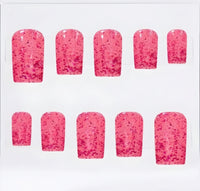 A set of ten press-on nails with a glossy hot pink base and dense dark pink glitter speckles, arranged in two rows of five on a plain white background.