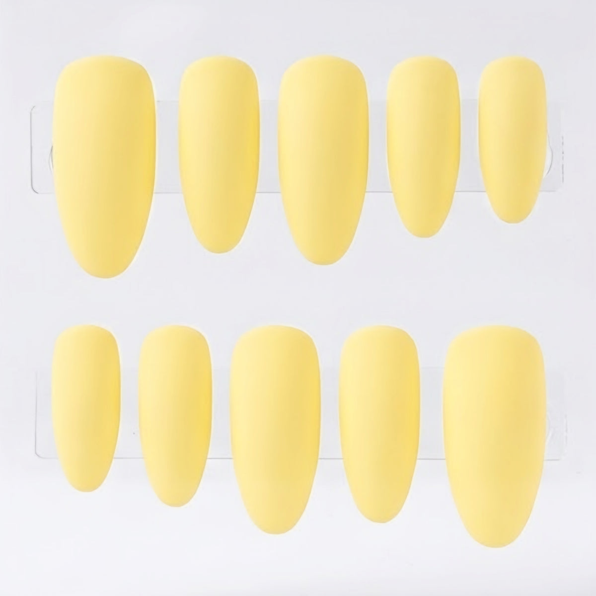 Ten yellow press-on nails arranged in two rows of five on a clear display card against a white background.