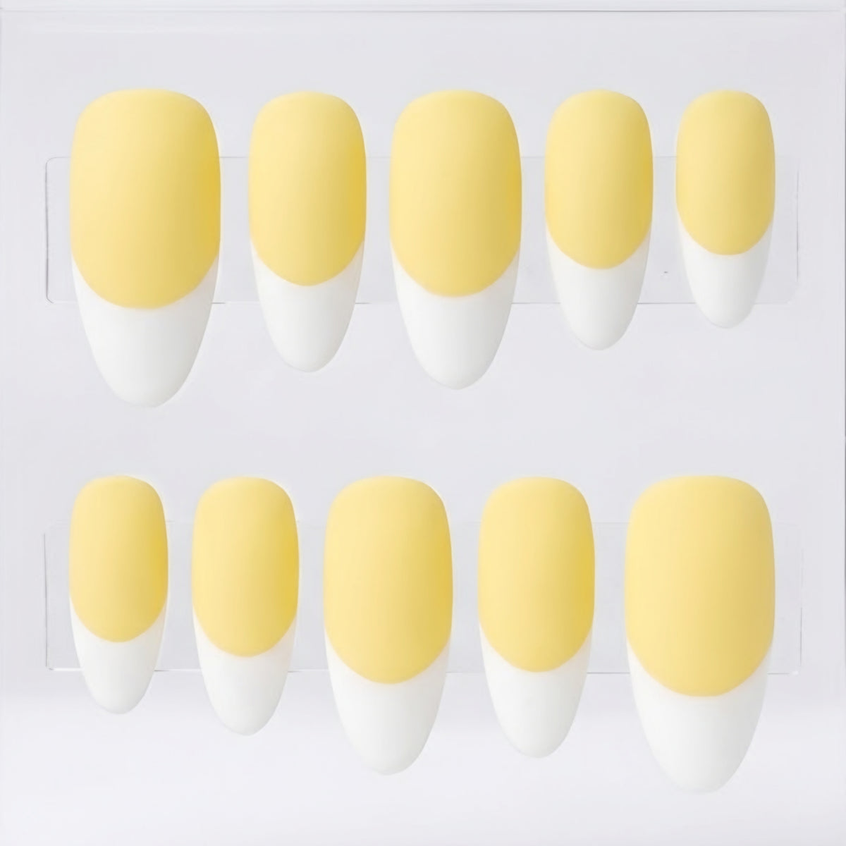 Ten false press-on nails arranged in two rows on a clear display card, featuring a matte pale yellow base and a white French tip.