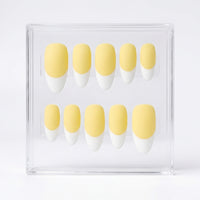 Ten-piece set of false press-on nails with a soft pastel yellow base and white French tips, displayed inside a clear acrylic case on a white background.