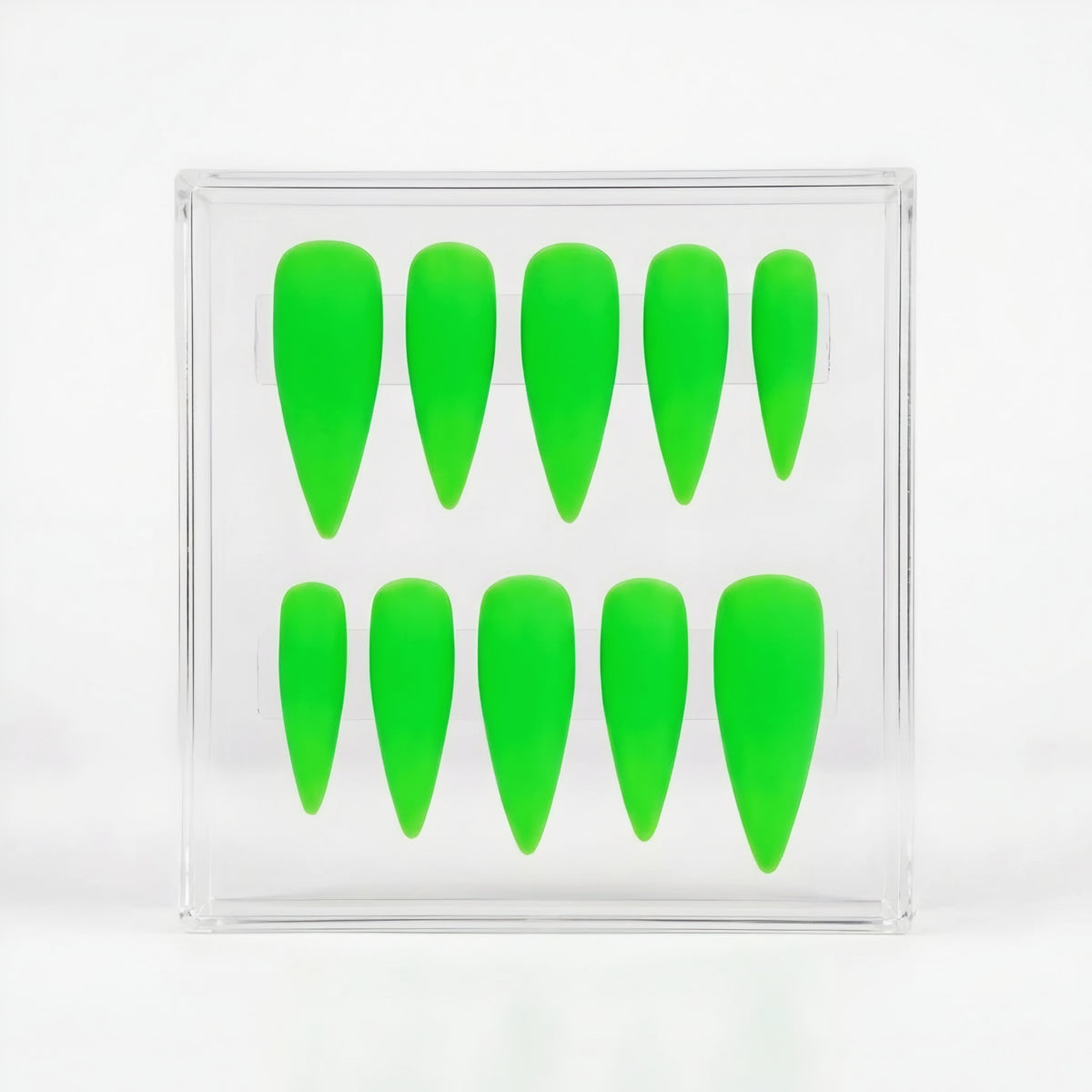 A set of ten bright neon green stiletto-shaped press-on nails arranged inside a clear acrylic display box on a white background.