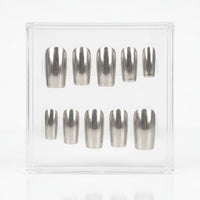 Ten metallic silver chrome press-on nails arranged in two rows inside a clear plastic display box on a white background.