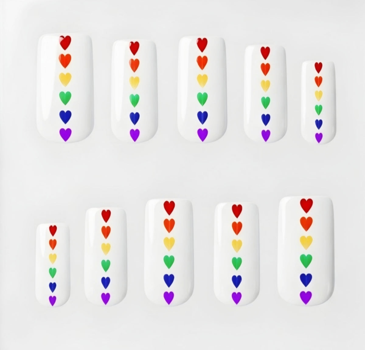 Set of 10 square glossy white press on nails with small rainbow hearts running down the centre. Displayed in a  clear display case on a white background.