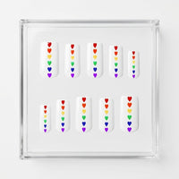 Set of 10 square glossy white press on nails with small rainbow hearts running down the centre. Displayed in a  clear display case on a white background.